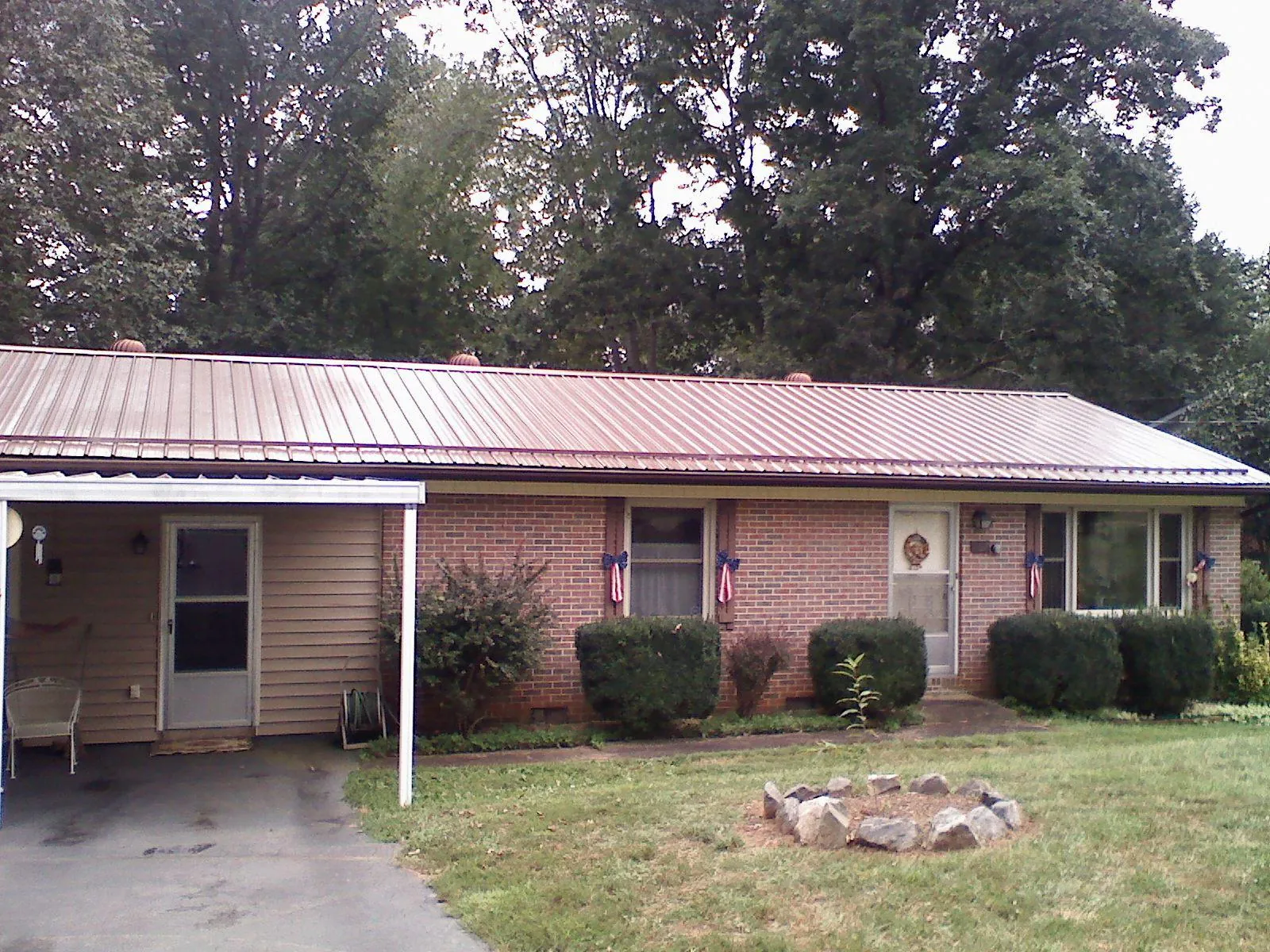 Bronze metal roof and carport on a brick ranch home — Roof Repair work by our crew in Pratts
